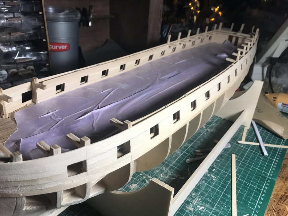 The deck covered while the ports are being sanded.