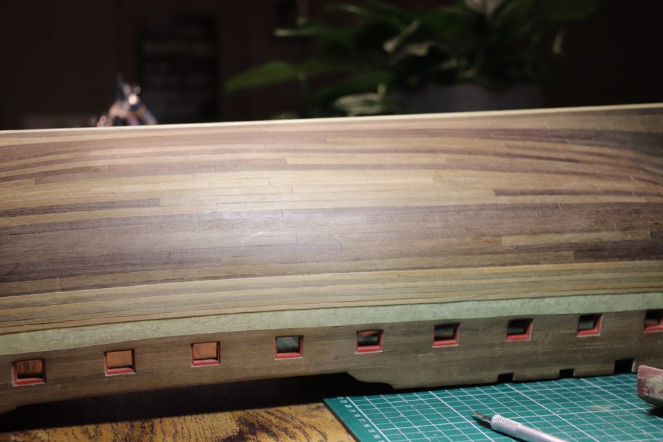 The wale is on: black strake and five strips follow the sheer of the hull as a single band.