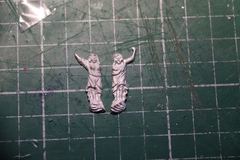 The two white metal ladies, the one on the right with an arm that is too short