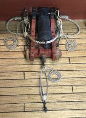 The ten visible guns with deck ropes, coiled on the deck