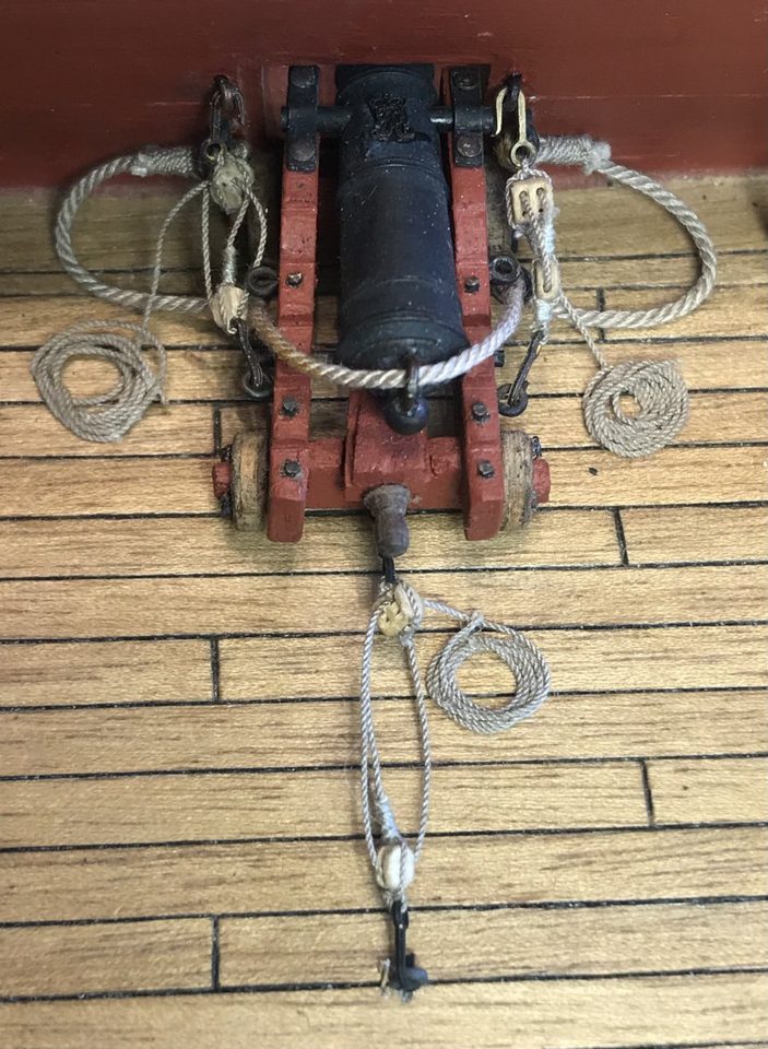 The ten visible guns with deck ropes, coiled on the deck