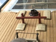 Bitts in front of a mast coat, seen across the capstan and the ladderway
