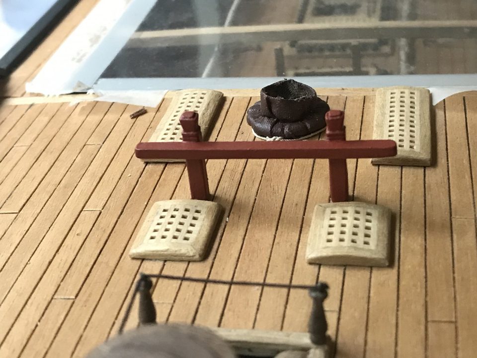 Bitts in front of a mast coat, seen across the capstan and the ladderway