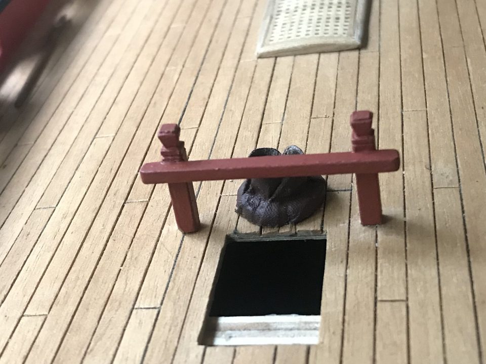 Bitts next to a ladderway, with a mast coat behind