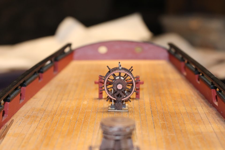 The ship's wheel seen along the length of the deck