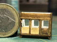 The first boxwood window next to a euro coin