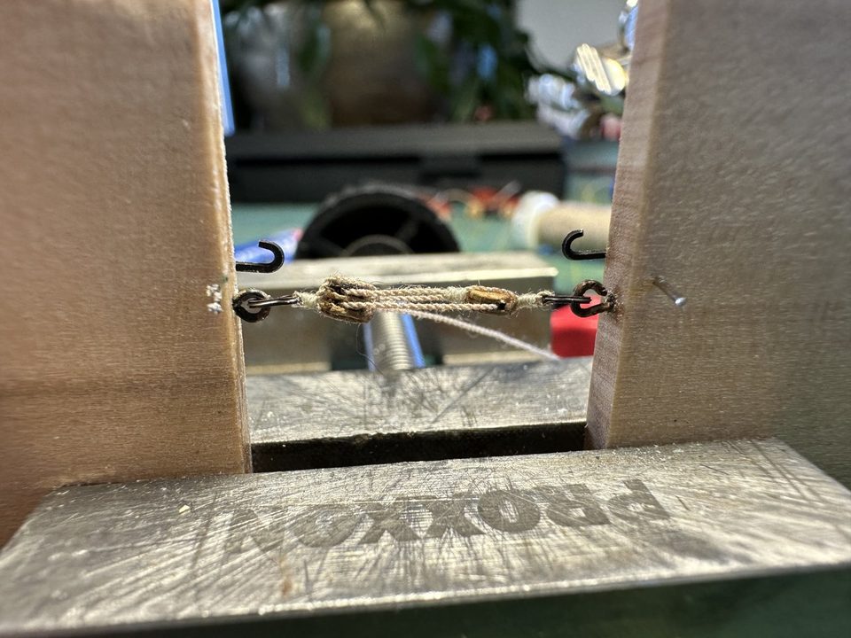 The jig: two blocks in the vice with a small hook, the tackle taking shape between them