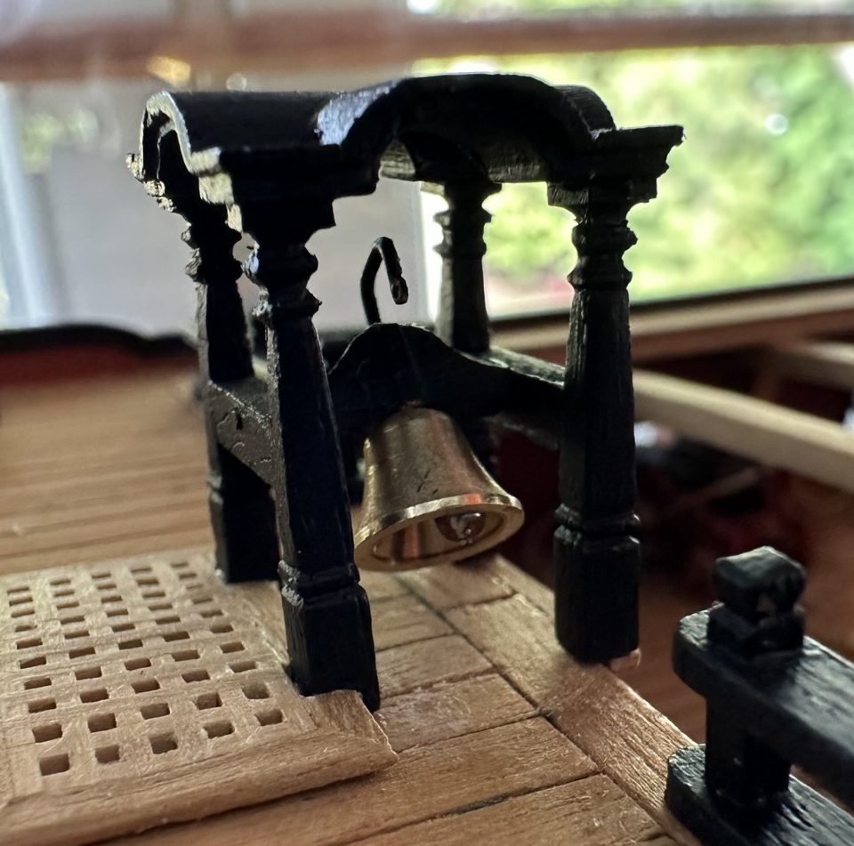 The belfry painted black on deck, with the bell and the clapper