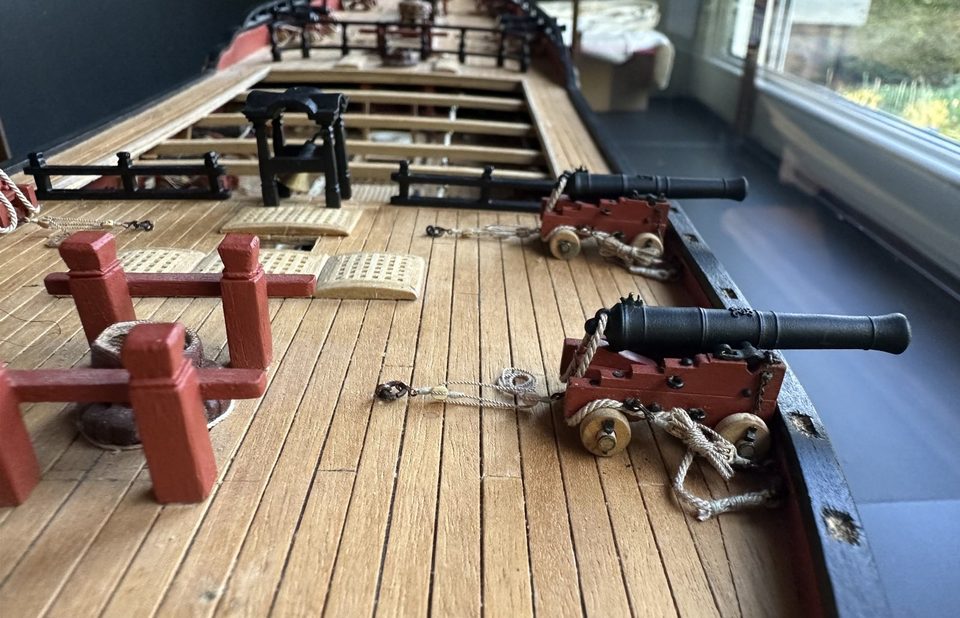 Looking forward along the deck: bitts, gratings, belfry and the port guns