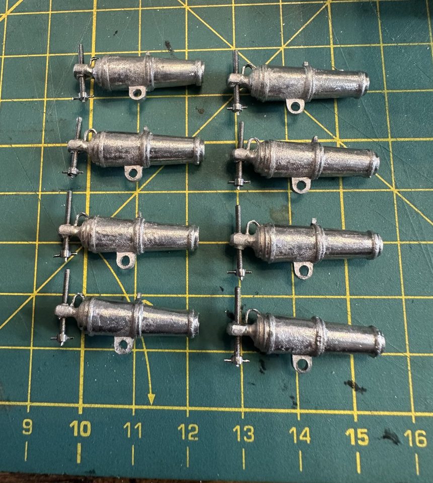 The eight carronades, each with its own elevating screw, still in bare white metal.