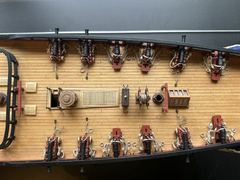From above: 9-pounders and carronades on both sides, with capstan, grating, ship's wheel and binnacle in the middle