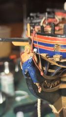 The bow of 1 mm brass wire in her left hand, the figure painted and offered up to the head