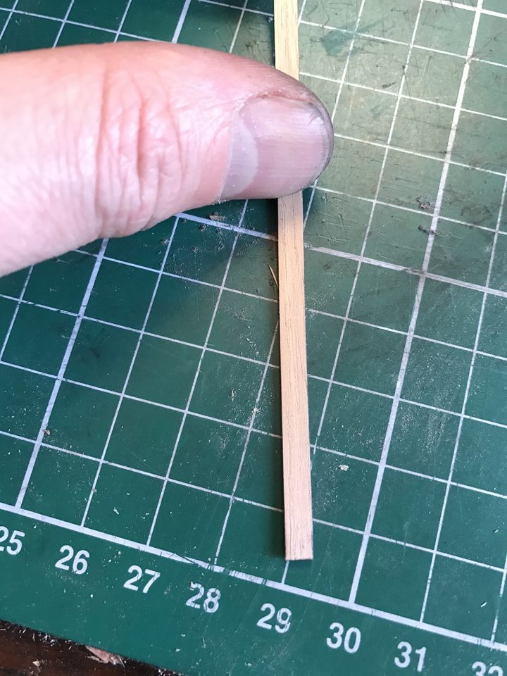 Measuring a strip against the ruler of the cutting mat.