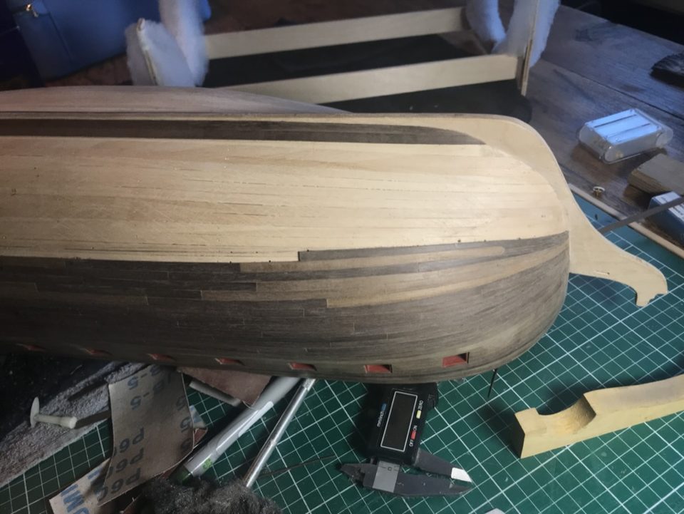 The bow after gluing the drop plank, with drawing pins in the strips and sandpaper ready for finishing.