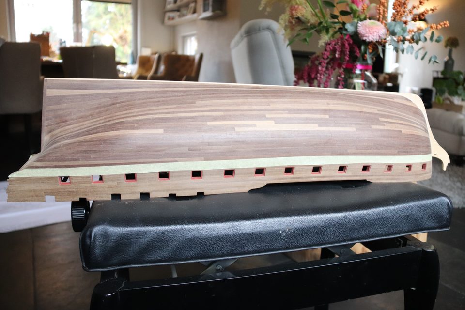 The hull on the stand with the masking tape as the height line for the black strake.