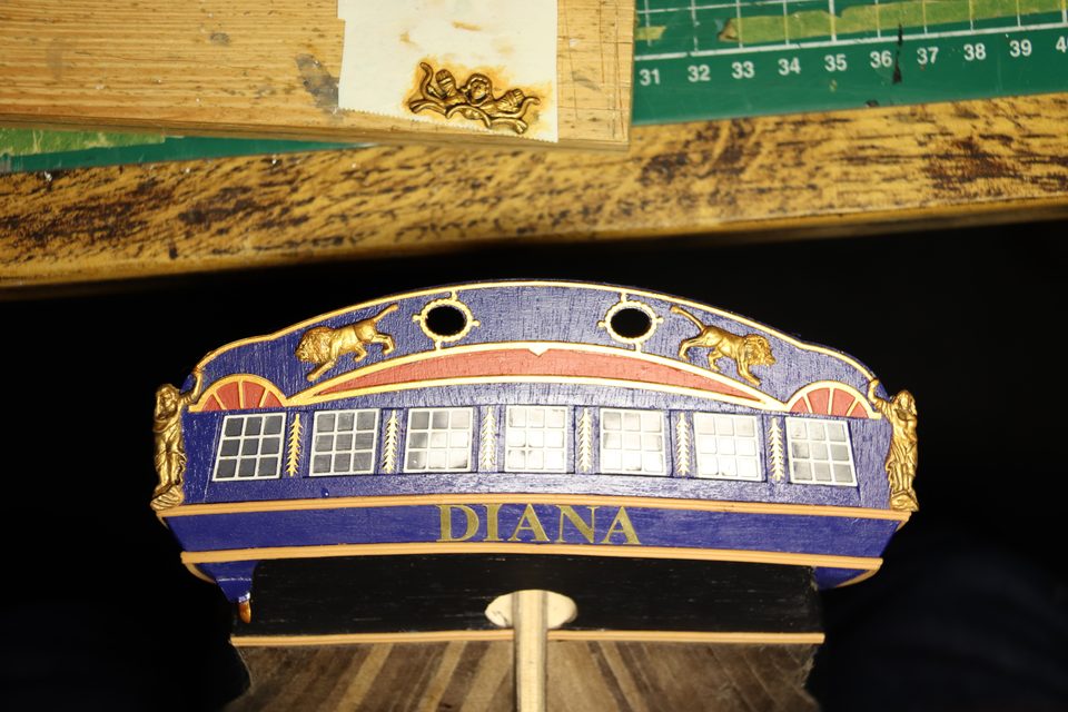 The transom with all the carvings in gold: figures, lions and centre carving.