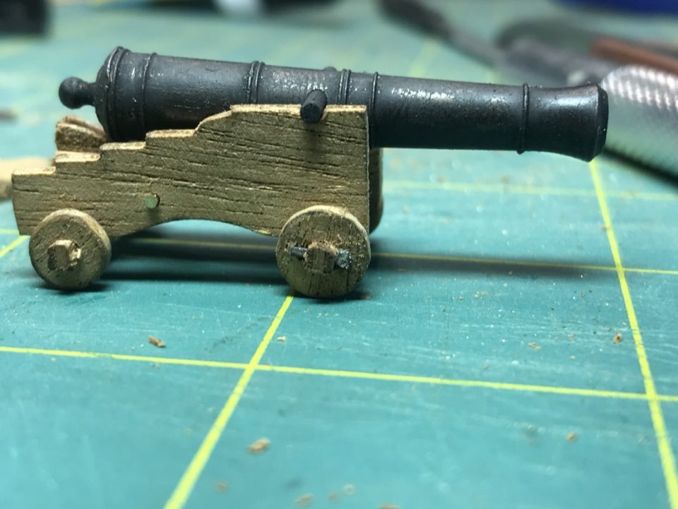 A blackened barrel on a still unpainted gun carriage: dull black, with the cast details clearly visible.