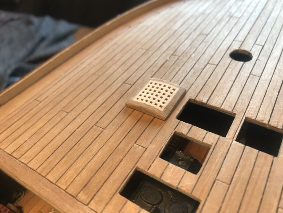 The grating in place on the deck, seen from the side, with the open hatch openings beside it.
