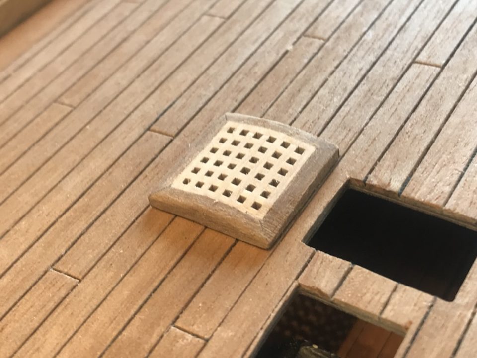 The lowered grating on the deck: the coaming stands only a millimetre or two proud, with the open hatch beside it.