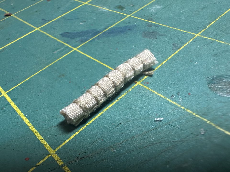 Van dichtbij: het opgerolde hangmatje met het touw er zeven keer omheen